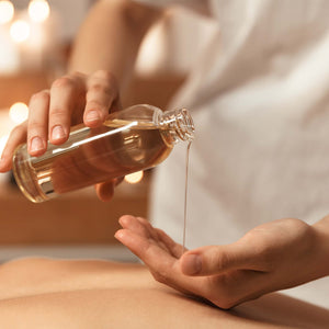 Close up woman pouring massage oil